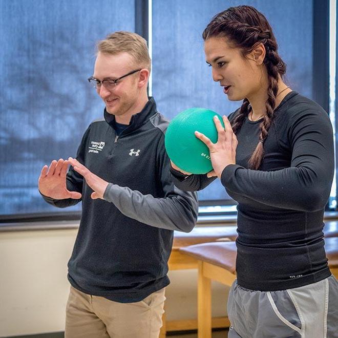 Athletic training student showing athlete proper throwing movement